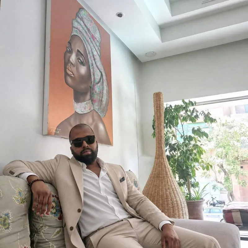 Yassine Dihabi, coach de vie, en costume beige dans un salon